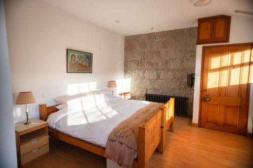 a bedroom with a large bed and a wooden door at Schoolhouse Ballater B&B in Ballater