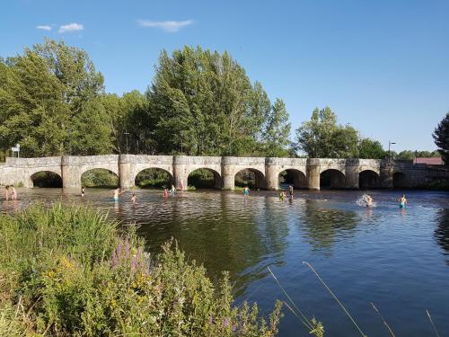 people swimming in the river under a bridge at La Casa de Salinas in Salinas de Pisuerga