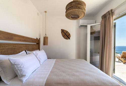 a bedroom with a bed with a view of the ocean at KaYa Tinos Luxury Villa - Helios in Agios Romanos