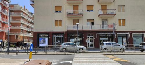 due auto parcheggiate di fronte a un edificio di Nice and Easy Apartment a Pietra Ligure