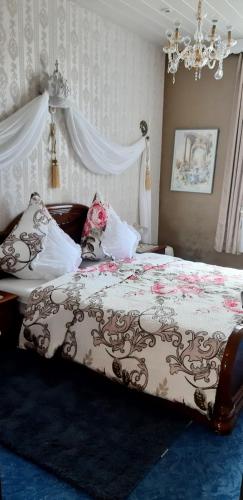 a bedroom with a large bed with a floral blanket at Gutshaus Nostalgie in Rätzlingen