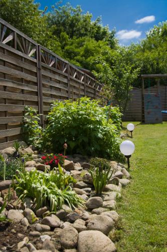 a garden with rocks and a wooden fence at Apartament Polaniczanka in Polanica-Zdrój