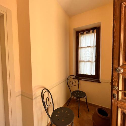 a room with two chairs and a window at B&B Podere Cottimellino - Montalcino - Val d'Orcia in Montalcino