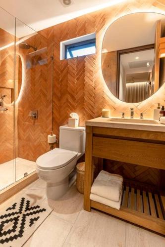 a bathroom with a toilet and a sink and a mirror at 6 Guests - Amazing Views -Top Design in San José del Cabo