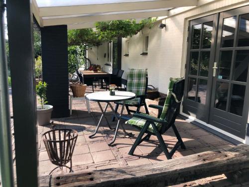 a patio with a table and chairs on it at Horse and Hound in Riethoven
