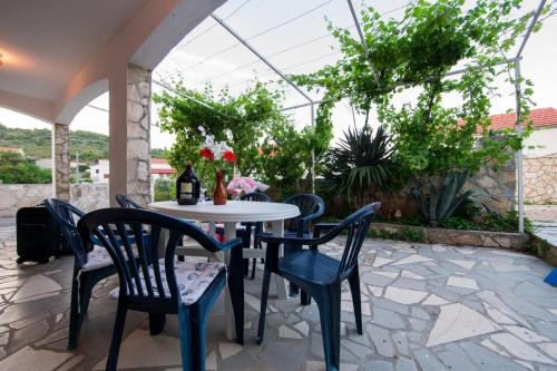 a patio with a table and chairs on a stone patio at Silver Beach Apartments Vis in Vis