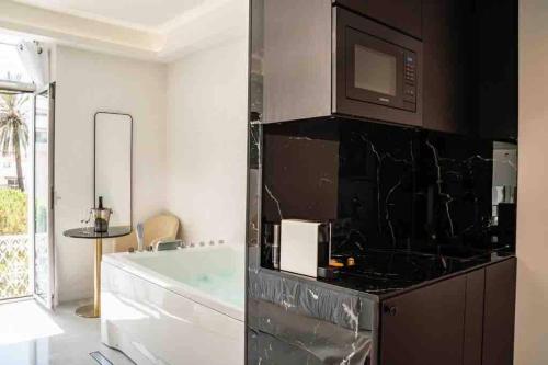 łazienka z wanną oraz kuchnia z kuchenką mikrofalową w obiekcie Suite luxe jacuzzi w Cannes