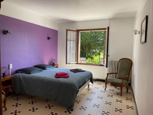 - une chambre avec un lit et un mur violet dans l'établissement Longère typique au milieu des châteaux de la Loire, à Bréhémont