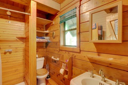 a bathroom with a toilet and a sink in a log cabin at Secluded Mountain Cabin with Decks and Gazebo! in Brasstown