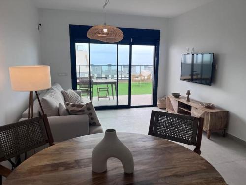 uma sala de estar com uma mesa e um sofá em Gran Apartment-Iconic Sea View em Gran Alacant