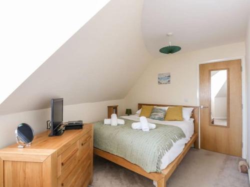 sypialnia z łóżkiem i komodą z telewizorem w obiekcie Beachside View w mieście Weymouth