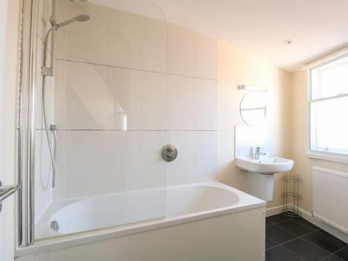 biała łazienka z wanną i umywalką w obiekcie Beachside View w mieście Weymouth