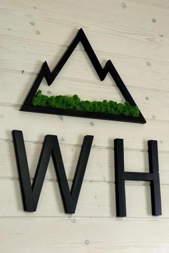 a black foreclosure sign with a black roof and green plants at Weekend house in Verkhovyna