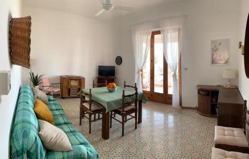 een woonkamer met een groene bank en een tafel bij Casa On The Beach in Alcamo