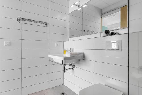 a white bathroom with a sink and a toilet at Icelandic Apartments by Heimaleiga in Reykjavík