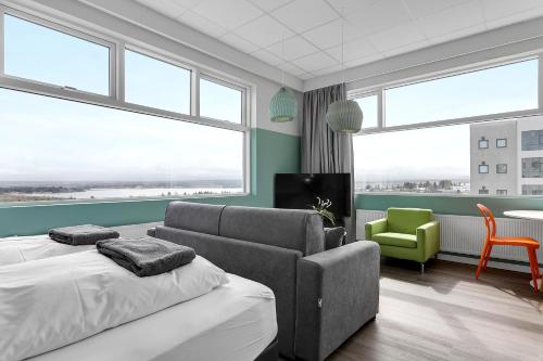 een kamer met 2 bedden en een bank en een stoel bij Icelandic Apartments by Heimaleiga in Reykjavík