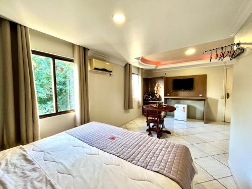1 dormitorio con 1 cama grande y cocina en Hotel Fenice, en Foz do Iguaçu