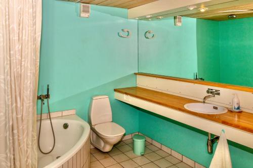 a blue bathroom with a toilet and a sink at Guesthouse at the boat harbour in Tórshavn