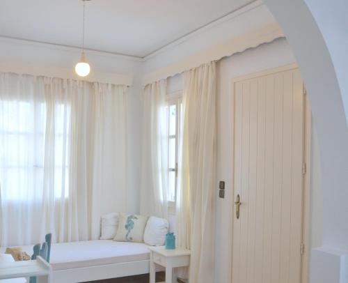 um quarto branco com um sofá e uma janela em ANIMA family apartment em Naxos Chora