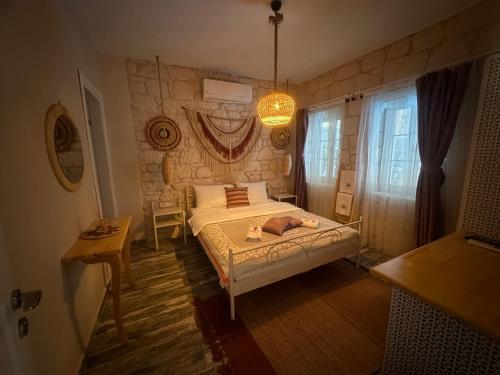 a bedroom with a bed and a table and a window at Hera Hotels Alaçatı in Cesme