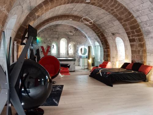 - une chambre avec un lit et un canapé dans un bâtiment dans l'établissement Luxueux Studio à Ambrières-les-Vallées - 85 m² avec Jacuzzi, à Ambrieres Les Vallees