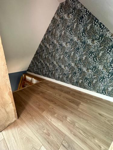 a room with a wooden floor and a wall at Gite confortable au milieu des prés - La ferme de Montigny in Neauphe-sur-Dives