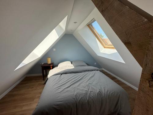 una camera da letto con letto in mansarda di Gite confortable au milieu des prés - La ferme de Montigny a Neauphe-sur-Dives