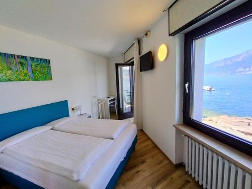 a bedroom with a bed and a large window at Hotel S.Maria in Brenzone sul Garda