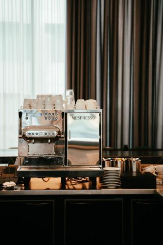 a table with a coffee maker and dishes on it at Residence Inn by Marriott Ghent in Ghent