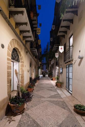 an alleyway in an old building with potted plants at Sofi' Center Rooms in Sciacca
