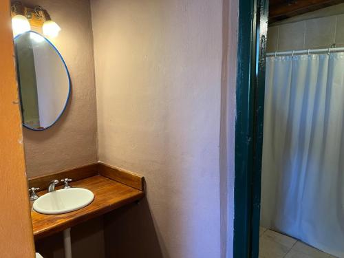y baño con lavabo, espejo y ducha. en Cabañas Los Cedros in 
