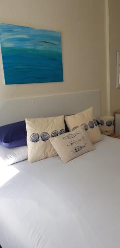 a white bed with pillows on top of it at Rose Court Holiday Apartments in Torquay