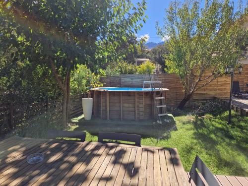 um quintal com uma banheira de hidromassagem e um deque de madeira em Pianotolinca em Moltifao
