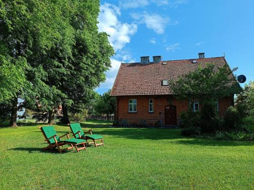two chairs and a table in front of a house at Pokrzepka in Spychowo