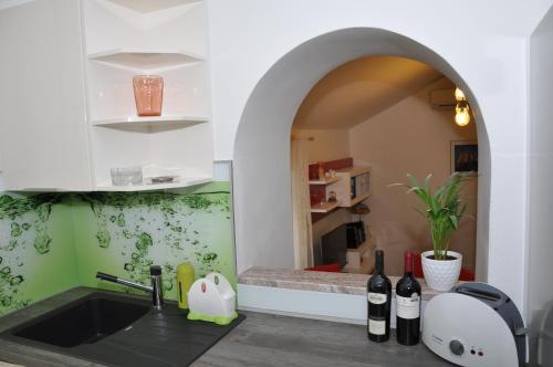 una cocina con fregadero y un arco con botellas de vino en Apartment Sweet Home en Split