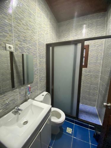 La salle de bains est pourvue d'un lavabo blanc et de toilettes. dans l'établissement Tropical Paradise, à São Tomé