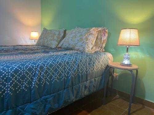 ein Schlafzimmer mit einem Bett und einer Lampe auf einem Tisch in der Unterkunft Tropical Paradise in São Tomé
