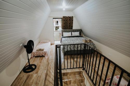 a attic room with a bed on a staircase at Recanto da Serra Chalé 02 in Mauá da Serra