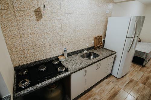 a kitchen with a sink and a refrigerator at Recanto da Serra Chalé 02 in Mauá da Serra
