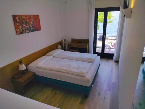 a bedroom with a bed and a door to a balcony at Hotel S.Maria in Brenzone sul Garda