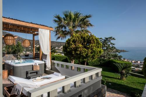 a balcony with a hot tub and a table at Everest Apartments and Suites in Stalida
