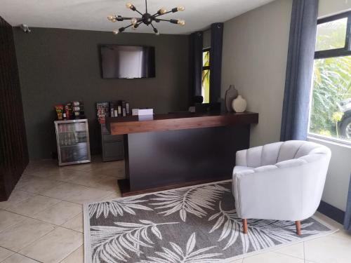 a living room with a white chair and a desk at L´Aurora Inn hostal in Guatemala