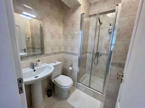 ein Bad mit einer Dusche, einem WC und einem Waschbecken in der Unterkunft Luxury Modern Beach Apartment in Quarteira