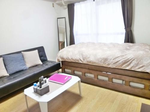 um quarto com uma cama, um sofá e uma mesa em Live Kyoto Kitaoji - Vacation STAY 13926 em Quioto