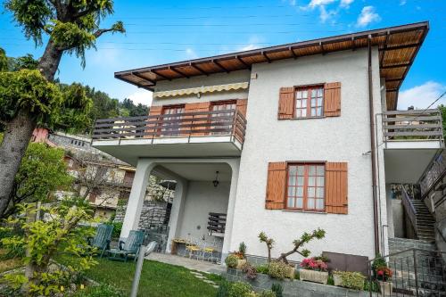 a house with a balcony and a tree at Villa Bianca in Varenna