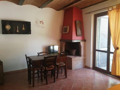 a dining room with a table and a fireplace at Il Casale di Luna in Saturnia