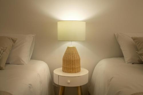 a lamp sitting on a table between two beds at Casa da Fonte in Vilarelhos