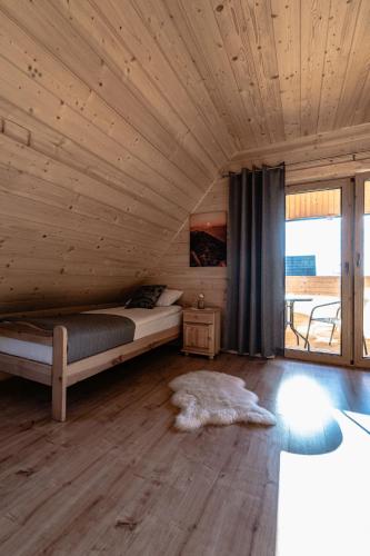 a bedroom with a bed and a wooden ceiling at Obrochtowa Chata in Kościelisko