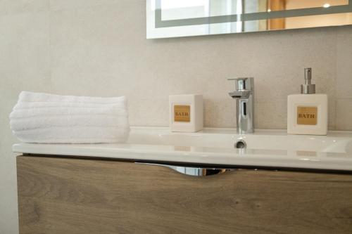 a bathroom sink with two soap dispensers on it at Casa da Fonte 