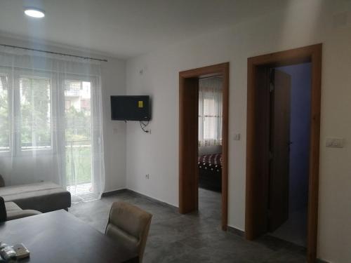 a living room with a couch and a tv on the wall at Apartman Jela in Soko Banja